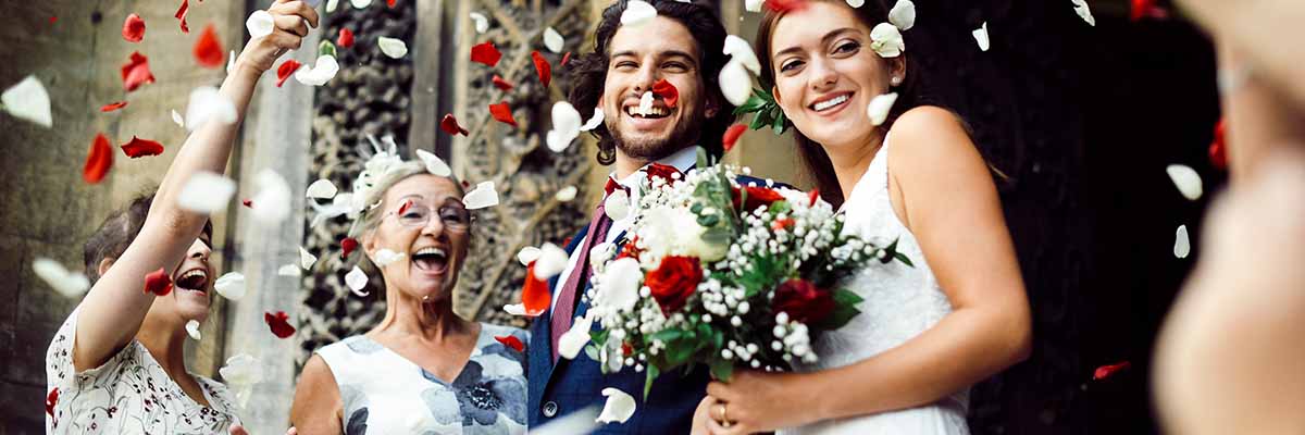 family-throwing-rose-petals-at-the-newly-wed-bride